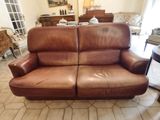a brown leather couch sitting in a living room