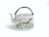 a tea pot with a bird on it on a white surface