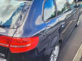 a black car parked in a parking lot next to other cars