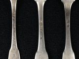 three forks and a spoon on a black surface