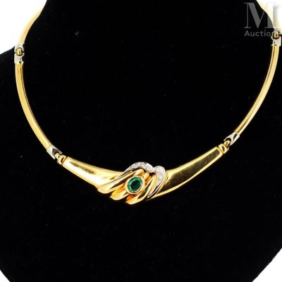 a gold necklace with a green stone in the center