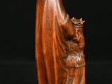 a wooden statue of a woman holding a basket of flowers