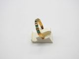 a close up of a gold ring with emerald stones