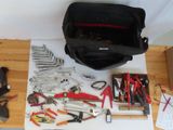 a bag of tools on a table with a lot of tools