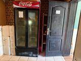 two refrigerators in a room with a brick wall behind them