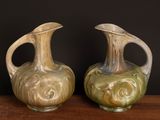 two vases sitting on a table with a black background