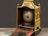 a gold clock sitting on top of a marble table