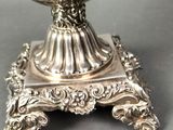 a silver plate with a bowl on it on a stand