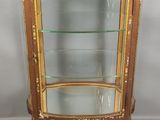 une vitrine ancienne dotée d'étagères en verre et de garnitures dorées