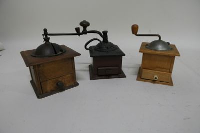 three different types of coffee grinders sitting on a white surface