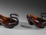 pair of wooden shoes with a swan on the heel