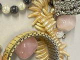many different necklaces and bracelets that are on a table