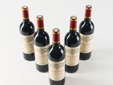 four bottles of wine are lined up in a row on a white surface