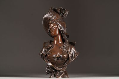 bronze bust of a woman with a hat on her head