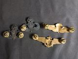four antique brass plated metal buttons and screws on a black background
