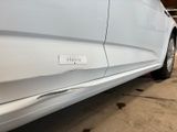 a white car parked in a garage with a sticker on the side of the car