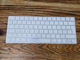 a white keyboard sitting on a wooden table next to a mouse