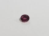 a pink tourmaline gems on a white surface
