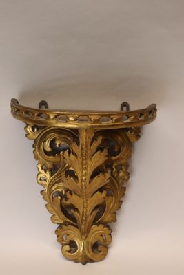 an ornate gold shelf with a decorative design on it