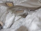 a white purse that is sitting on top of a bed