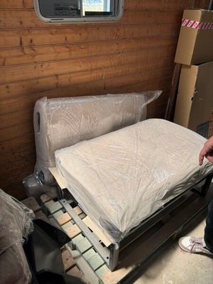 un homme debout à côté d'un lit dans une chambre