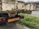 a rusted dump truck parked on the side of the road