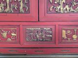 a red cabinet with gold decorations on it