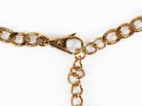 a close up of a gold chain with a heart charm on it