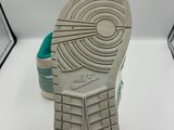 Quelqu'un tient une paire de chaussures sur une surface blanche
