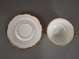 two cups and saucers with gold rims are sitting on a table