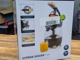 packaging of a juicer sitting on a wooden table in a garage