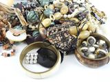 a pile of assorted jewelry on a white surface