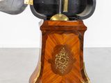 a clock that is sitting on top of a wooden stand