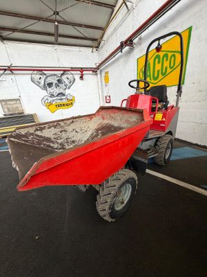a red tractor with a red trailer parked in a garage