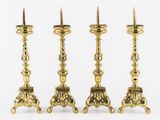three brass candlesticks with ornate designs on each of them