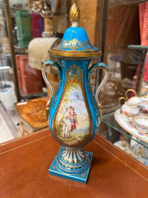 a blue and gold vase sitting on top of a wooden table