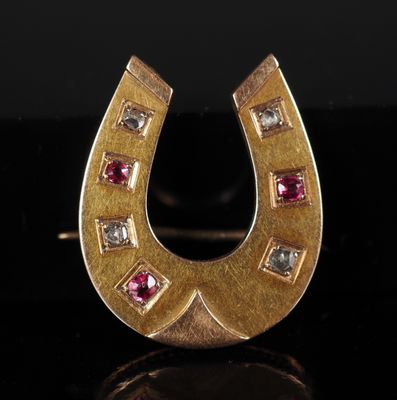 a close up of a gold horseshoe shaped ring with pink and white stones