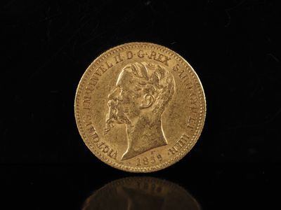 gros plan d'une pièce d'or sur une surface noire