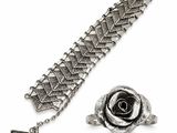 a close up of a silver bracelet with a rose on it