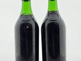 deux bouteilles de vin posées sur une table l'une à côté de l'autre