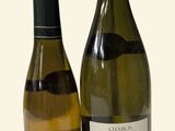 two bottles of wine sitting next to each other on a table