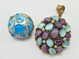 two pendants of blue and purple stones on a white surface