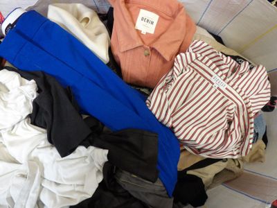 a pile of clothes in a basket on the floor