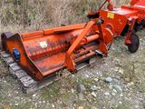 an orange tractor plow sitting on the side of the road