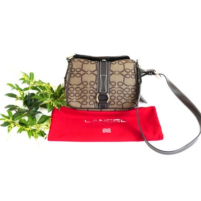 the purse is sitting next to a red bag and a plant