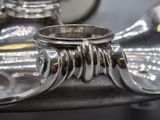 a close up of a silver tea pot with a silver handle