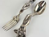 two spoons and a fork sitting on a table