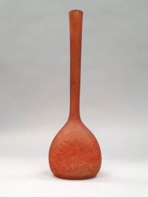 a red vase that is sitting on a white surface