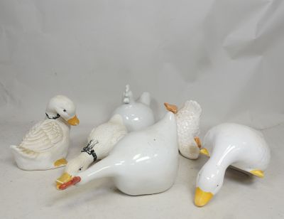 five white ducks sitting on a white surface