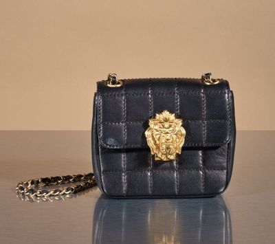an image of a black purse with a gold lion head on it